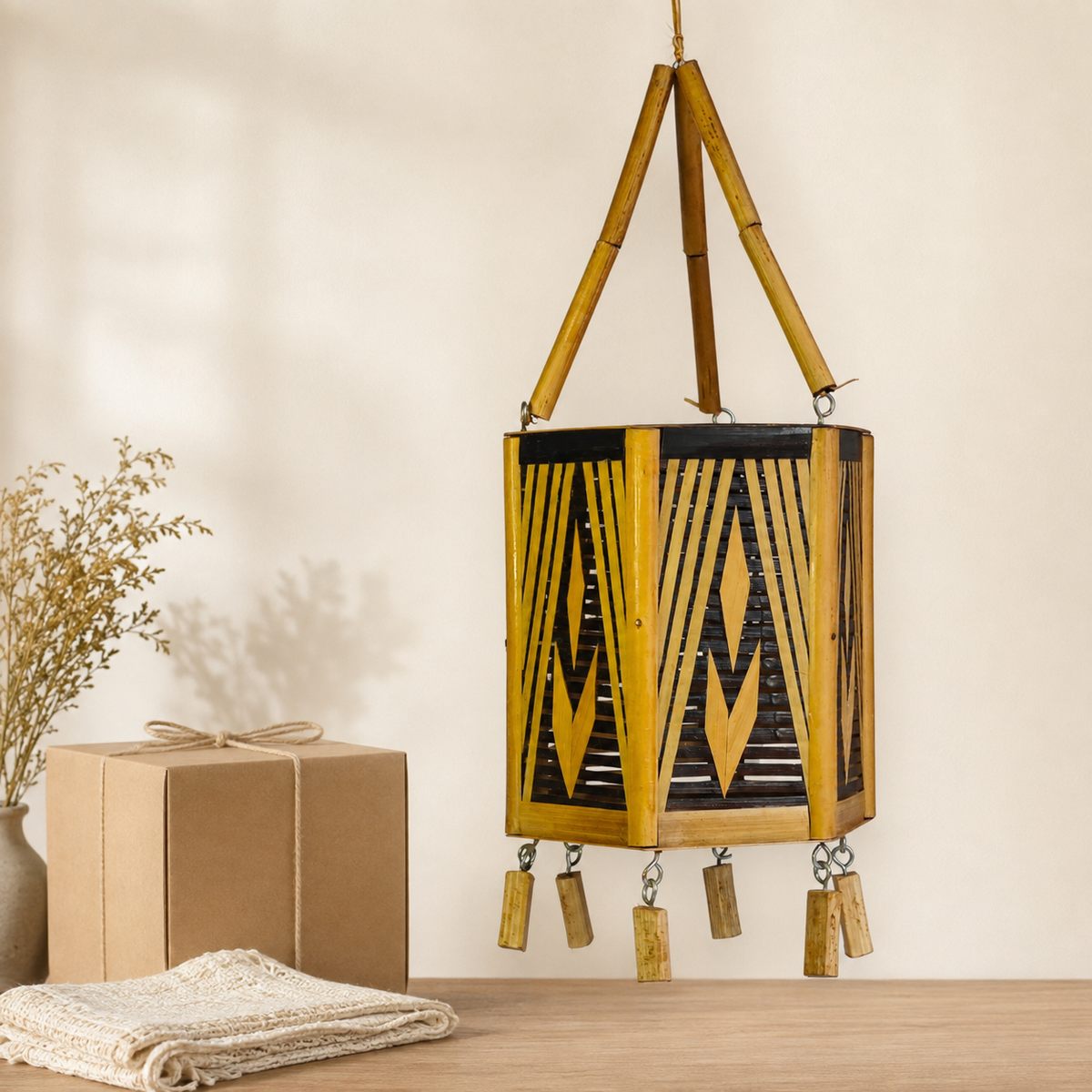 Handcrafted Bastar bamboo hanging lamp presented beside a kraft gift box and woven cloth