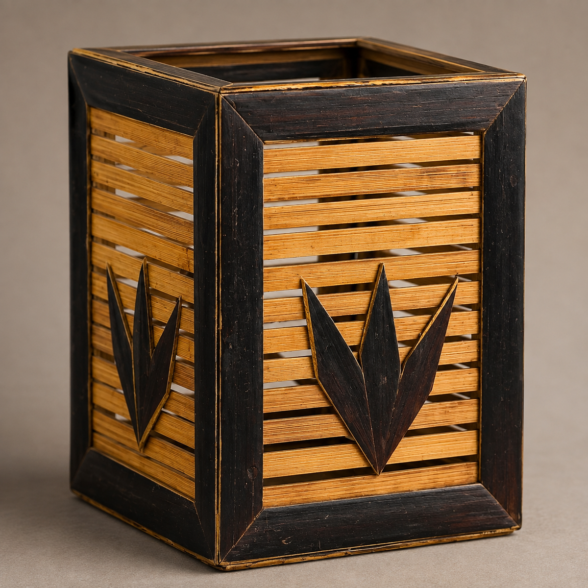 Close view of the bamboo slats, dark frame and leaf motifs on a Bastar pen stand