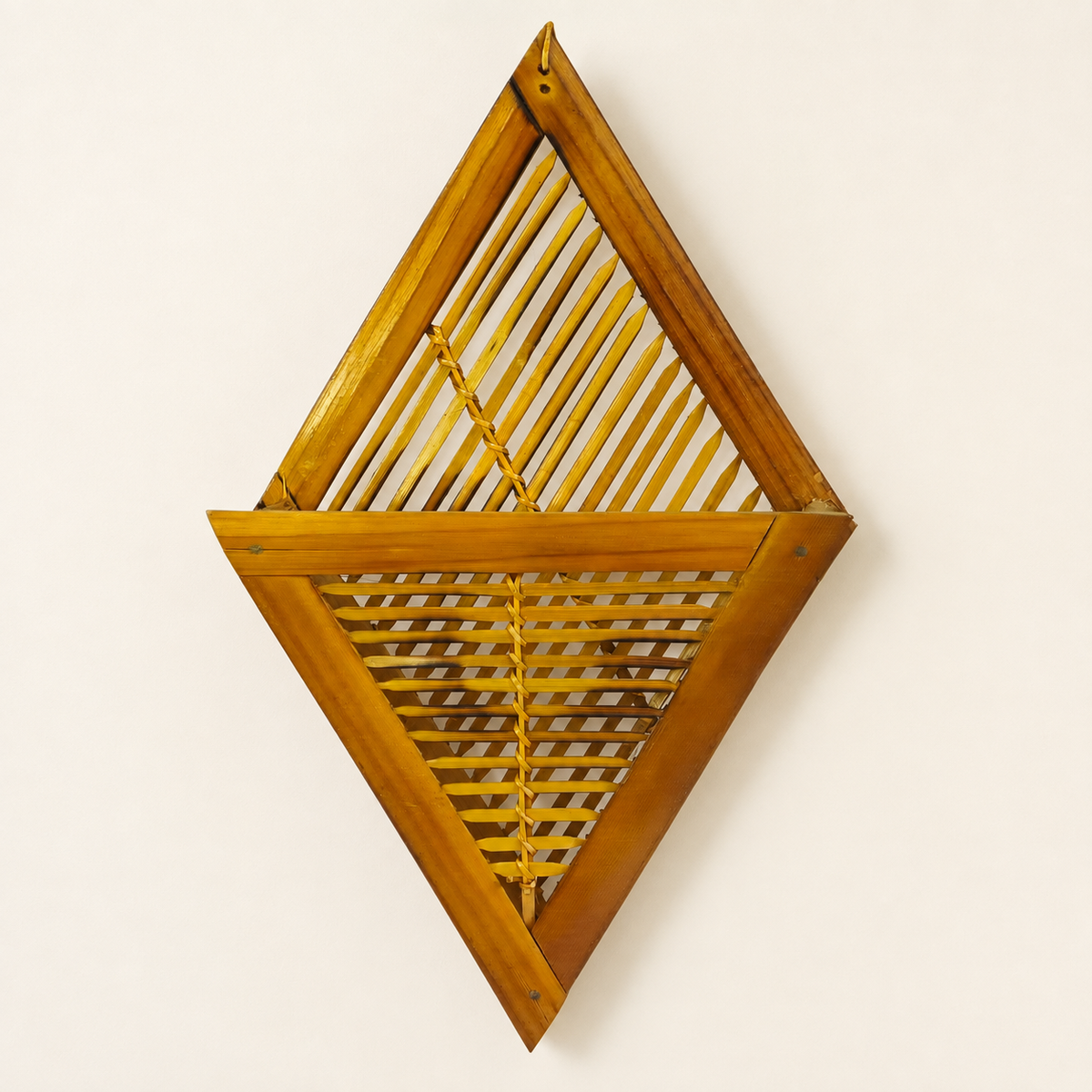 Honey-golden handcrafted bamboo wall frame holder on a clean warm-white studio wall