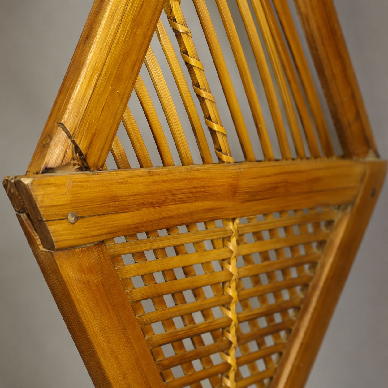 Close detail of woven bindings, lattice slats, fasteners, and grain on the bamboo wall holder