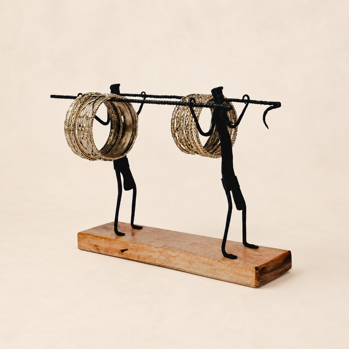 Bastar wrought iron bangle stand with two gold-toned bangle clusters on ivory