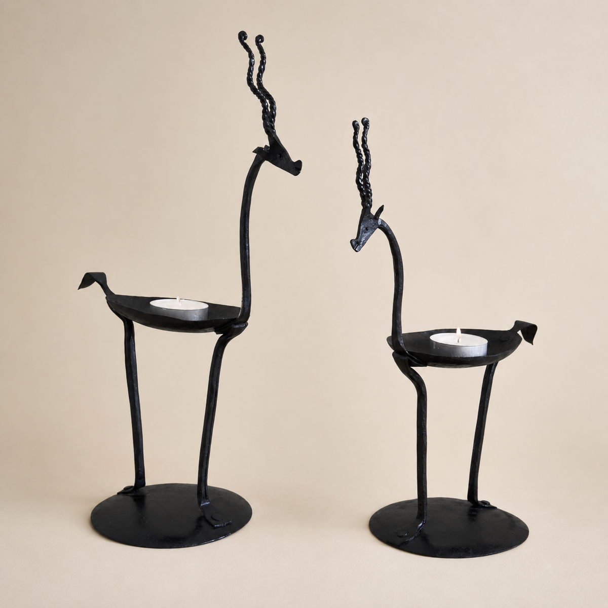Pair of Bastar wrought iron bird candle holders on a warm ivory studio background