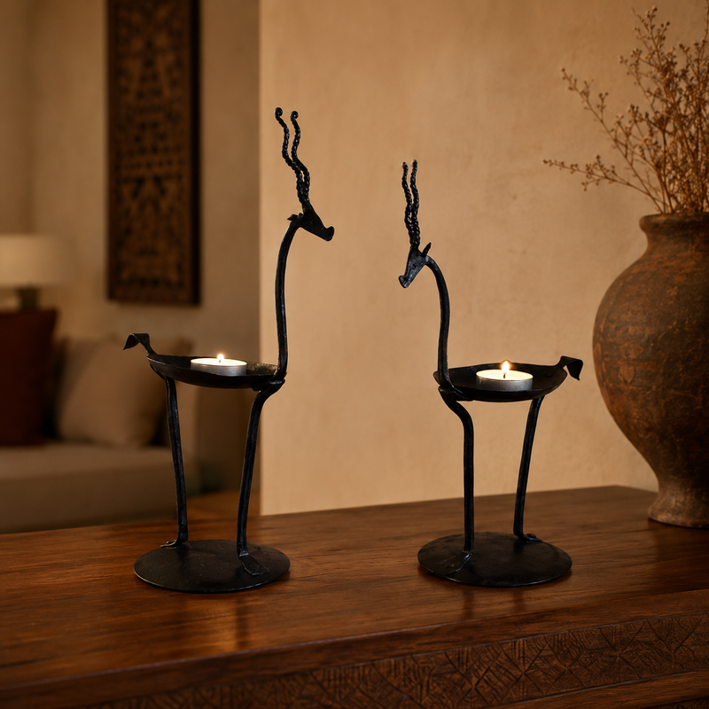 Bastar wrought iron bird candle holder pair with lit tealights on a walnut console