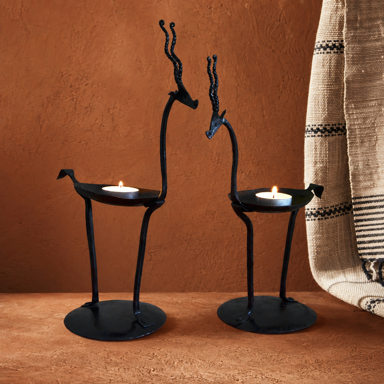 Bastar wrought iron bird candle holder pair in an earthen craft-inspired setting