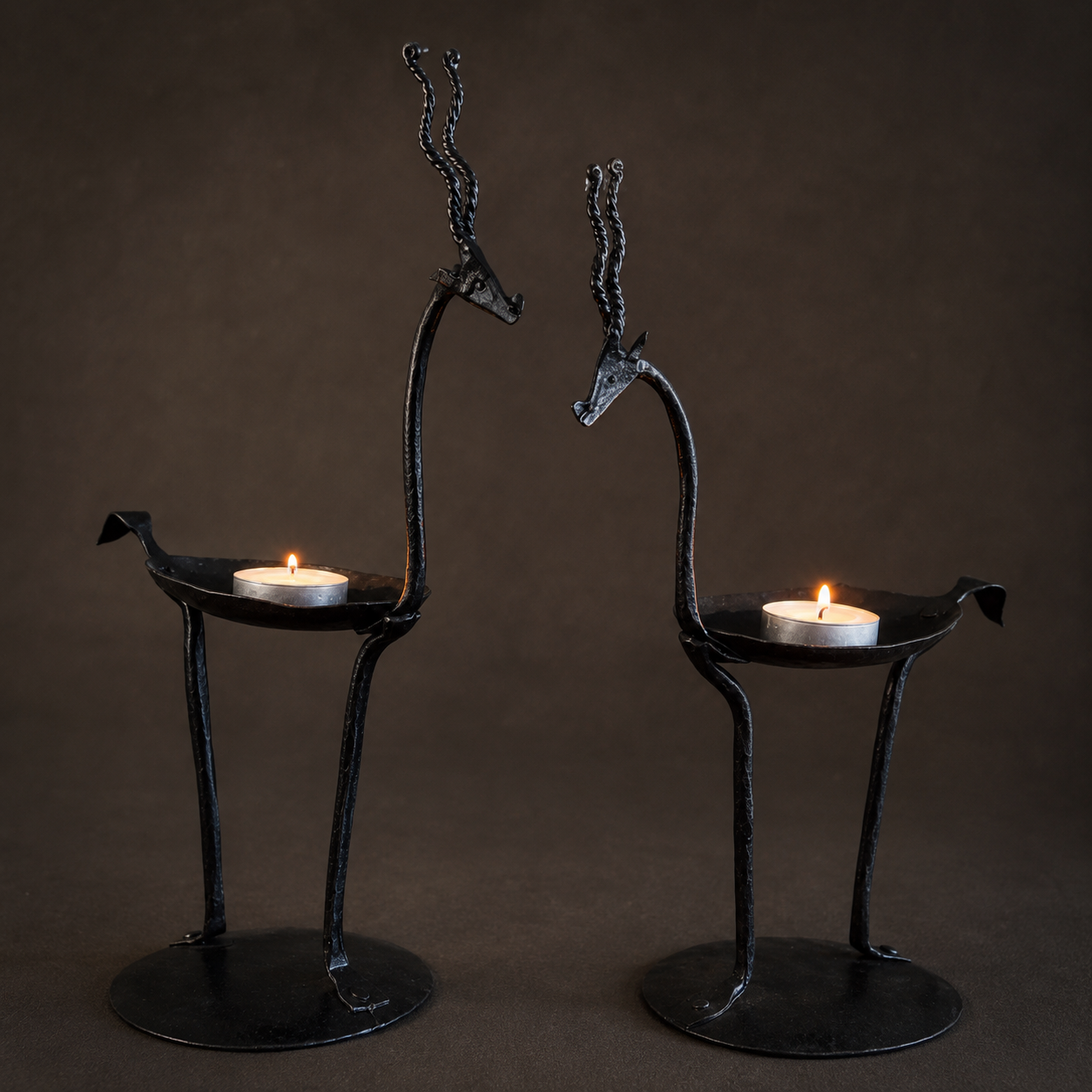 Close view of the forged iron texture, twisted horns, bird trays, and candle cups