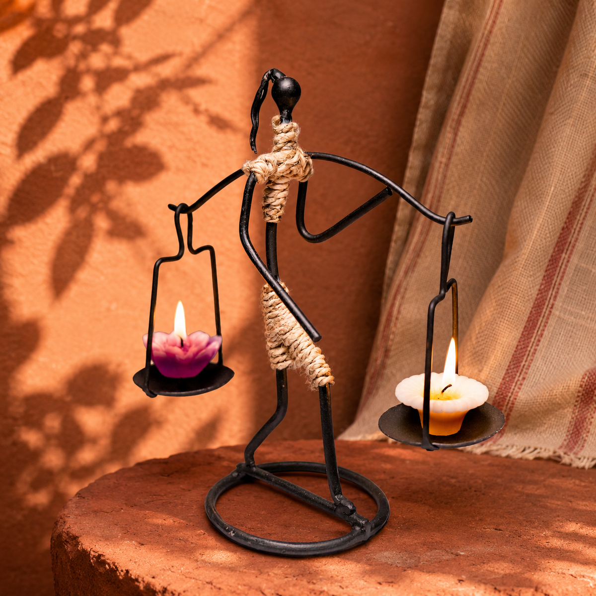 Bastar wrought iron two-candle figure holder in an earthy craft editorial setting