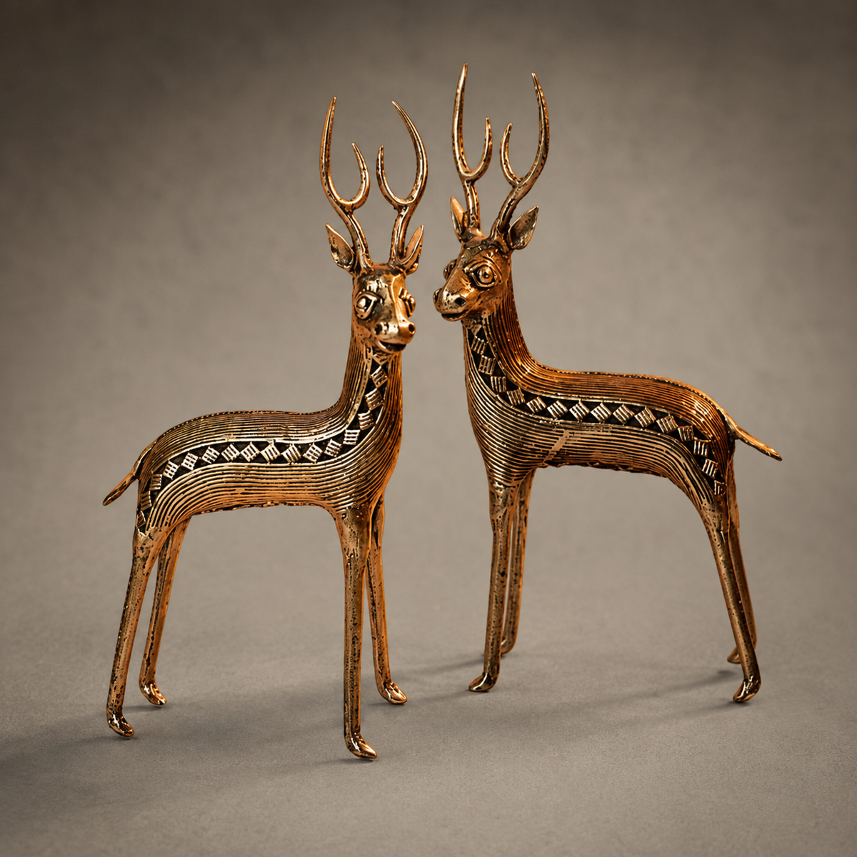 Close craftsmanship view of the ribbed brass and geometric detailing on the Dhokra deer pair