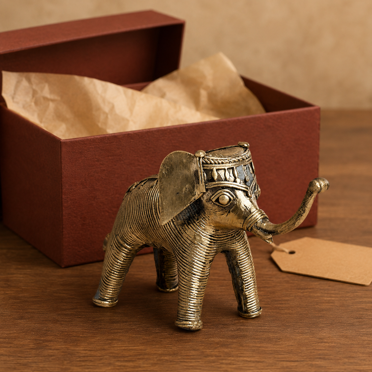 Dhokra Elephant Design 7 beside an open gift box with a blank kraft tag