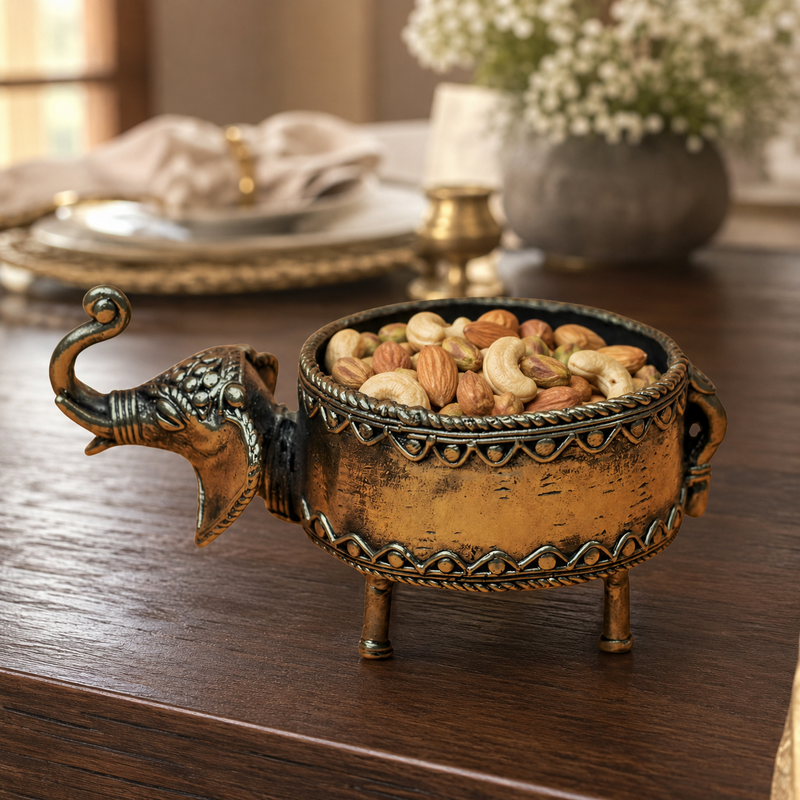 Dhokra elephant dry fruit holder serving assorted nuts on a teak dining table
