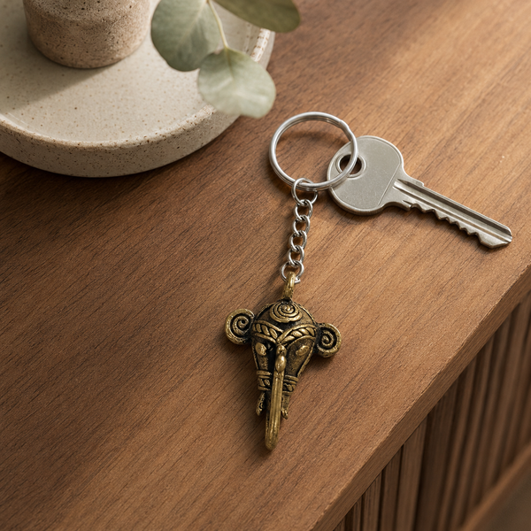 Dhokra elephant keyring attached to a house key on a warm wooden entryway table
