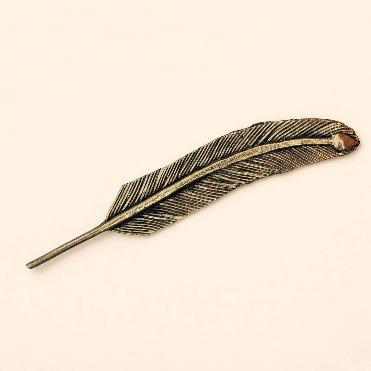 Dhokra brass feather bookmark on a warm ivory studio background
