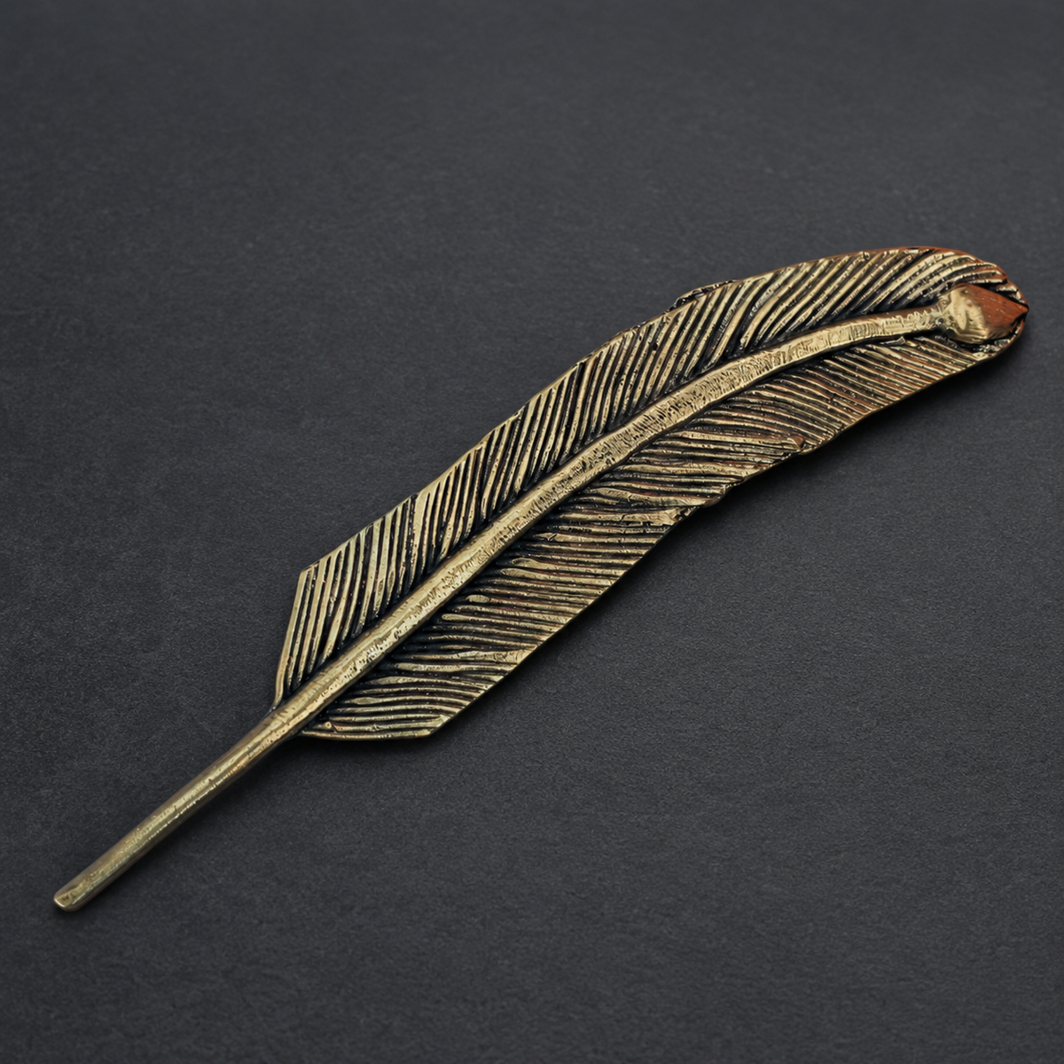 Detailed Dhokra feather bookmark showing incised barbs and antique brass patina