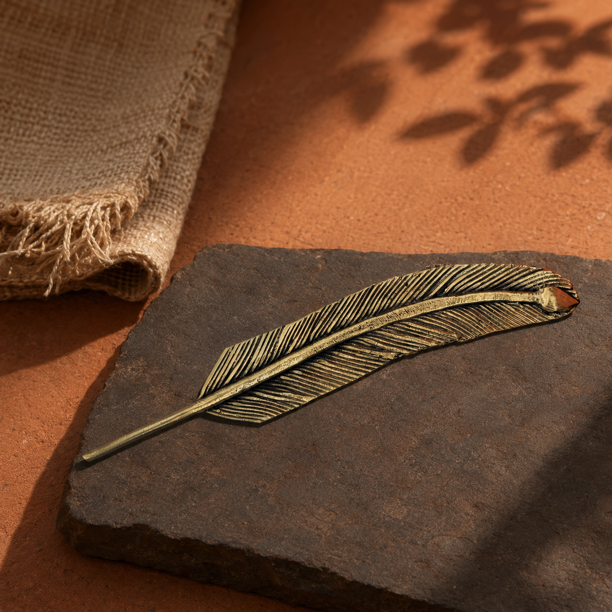 Dhokra brass feather bookmark in an earthy Bastar-inspired editorial setting