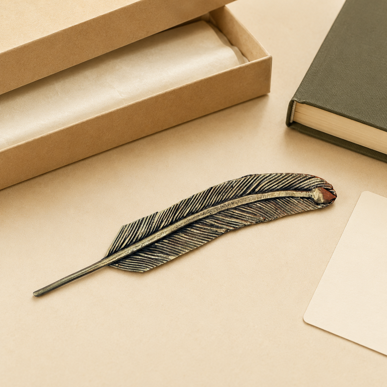 Dhokra brass feather bookmark beside a presentation box, book and blank gift card