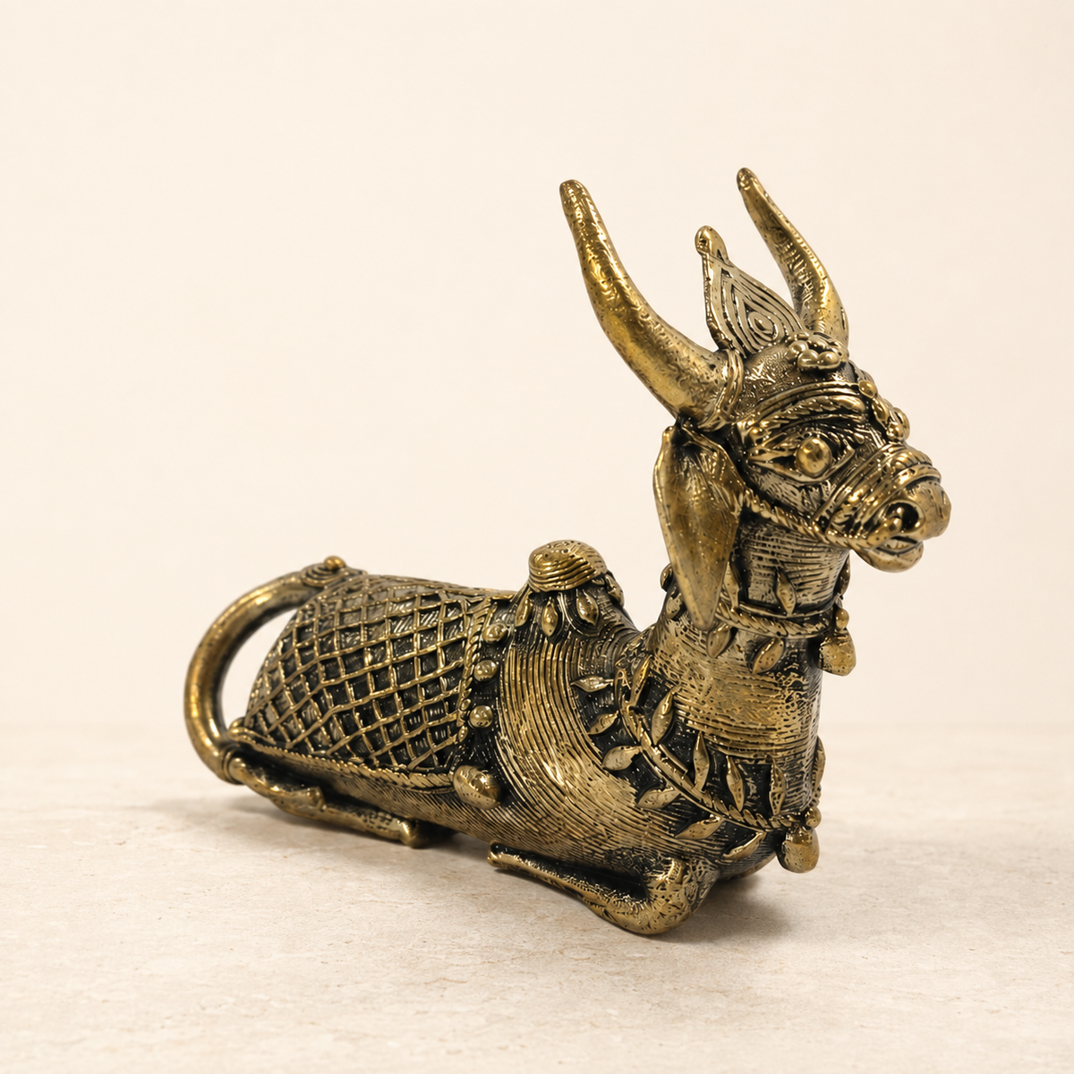Dhokra Mini Nandi brass paperweight on a clean warm ivory studio background