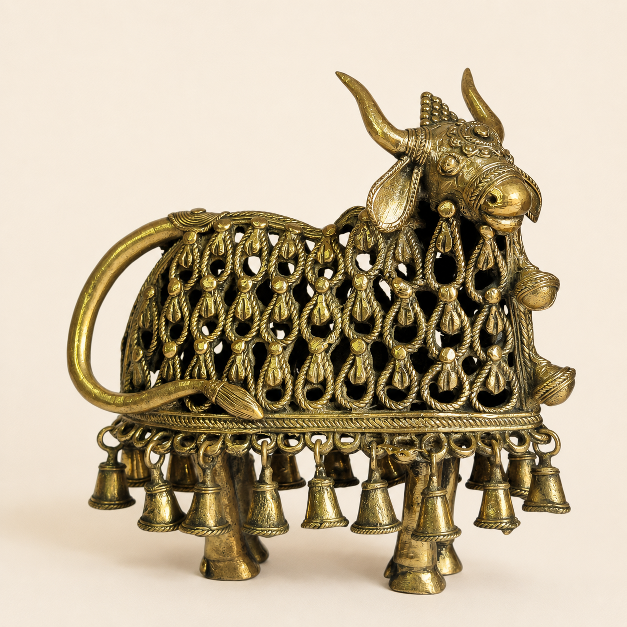 Dhokra Nandi Bell Design brass figurine on a warm ivory studio background