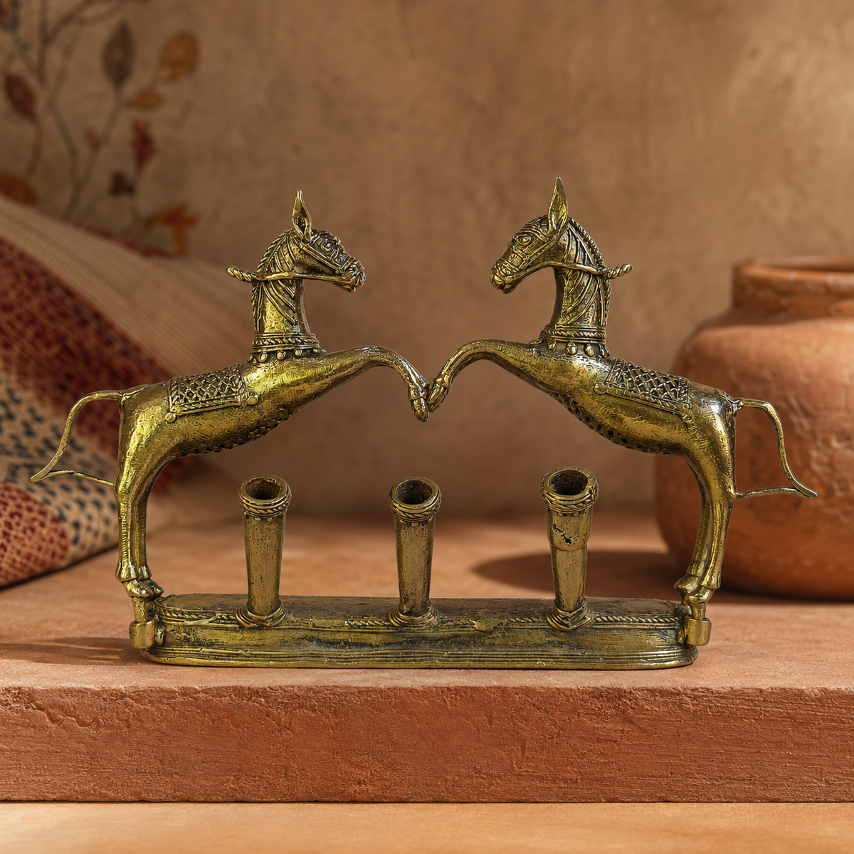 Dhokra Pen Holder Design 1 displayed on a terracotta plinth in a Bastar-inspired setting