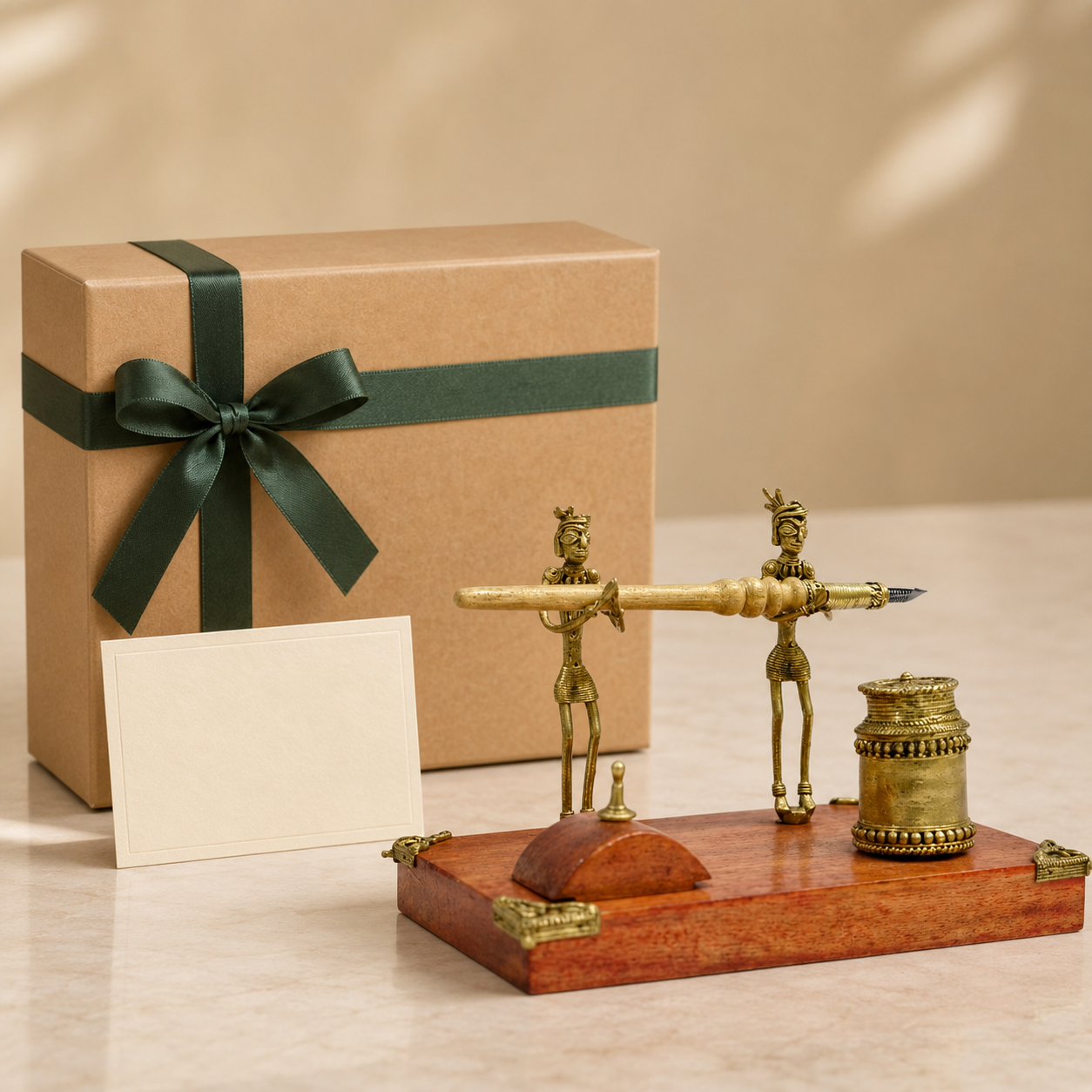 Dhokra pen stand with two tribal figures, wooden base, horizontal pen and cylindrical holder beside a ribboned gift box