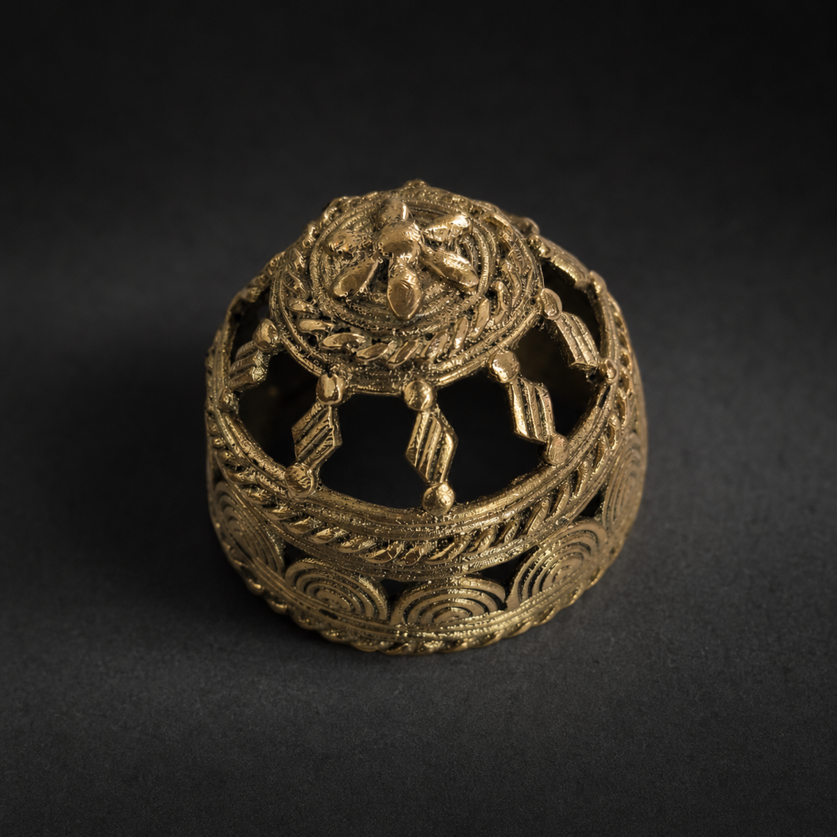 Detailed view of the openwork lost-wax brass motifs on the Dhokra paperweight