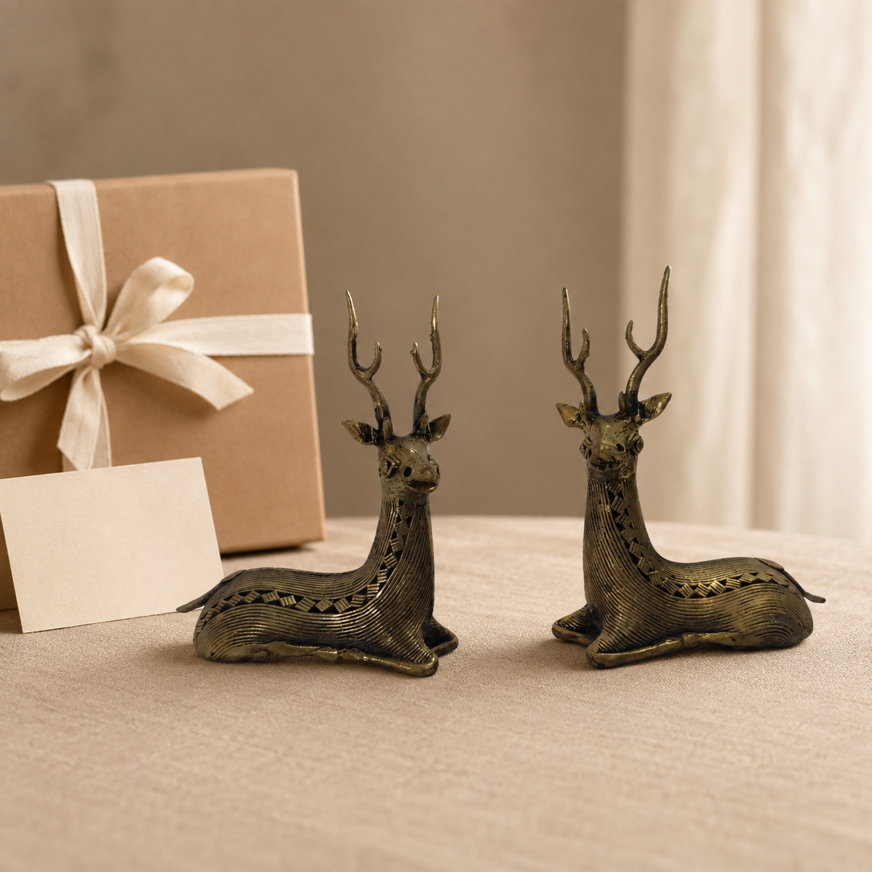 Two-piece Dhokra swamp deer set presented beside a ribboned kraft gift box for scale