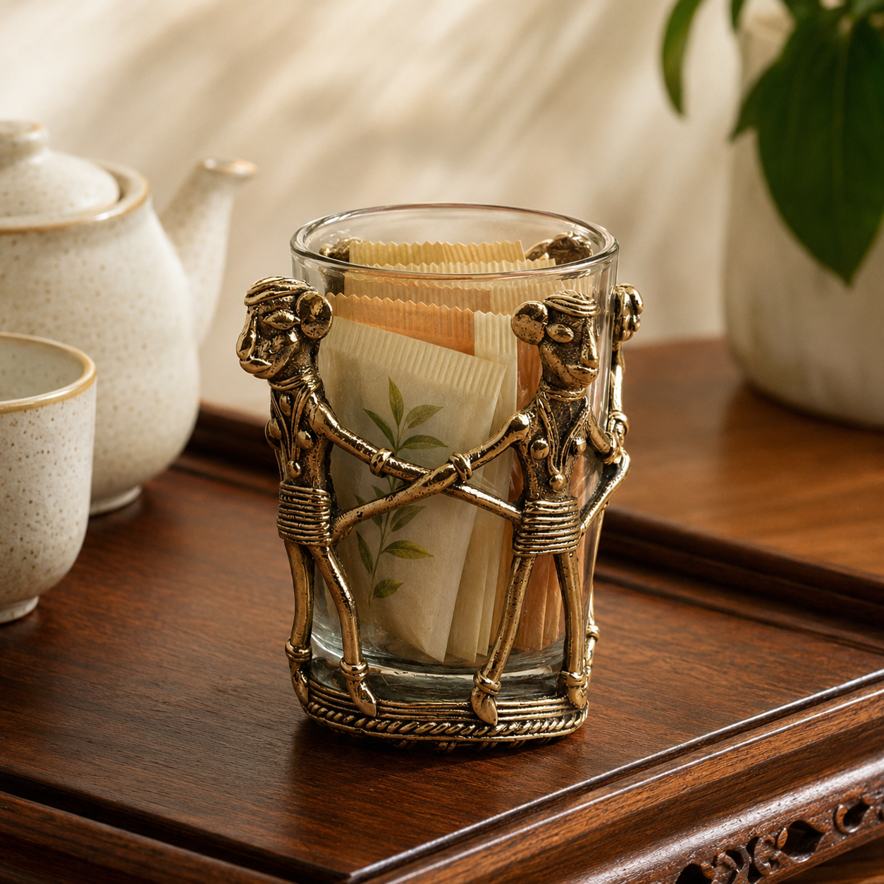 Dhokra brass tea holder with tea sachets in a warm tea-serving setting