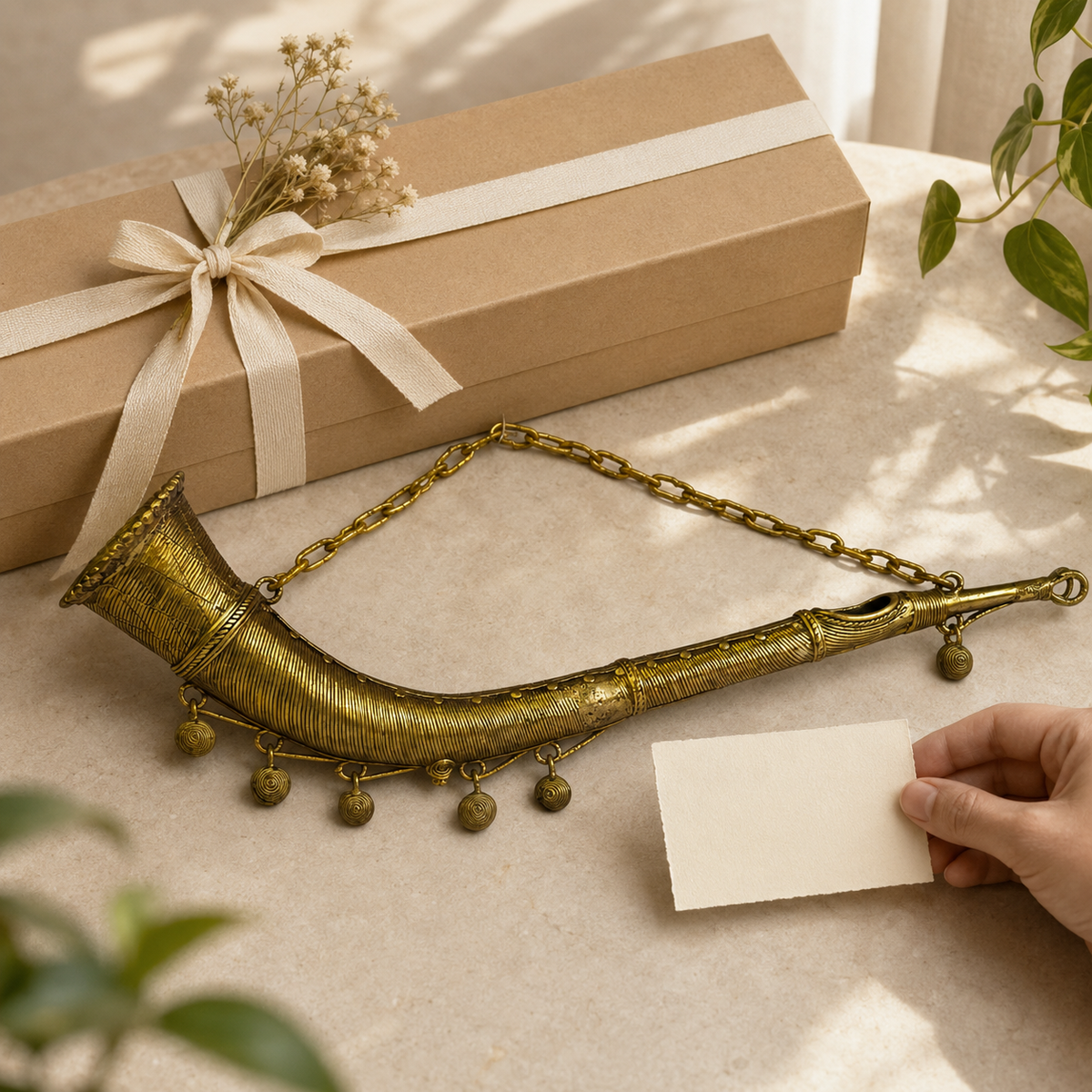 Dhokra Todi curved brass tribal horn beside a ribboned gift box and note card