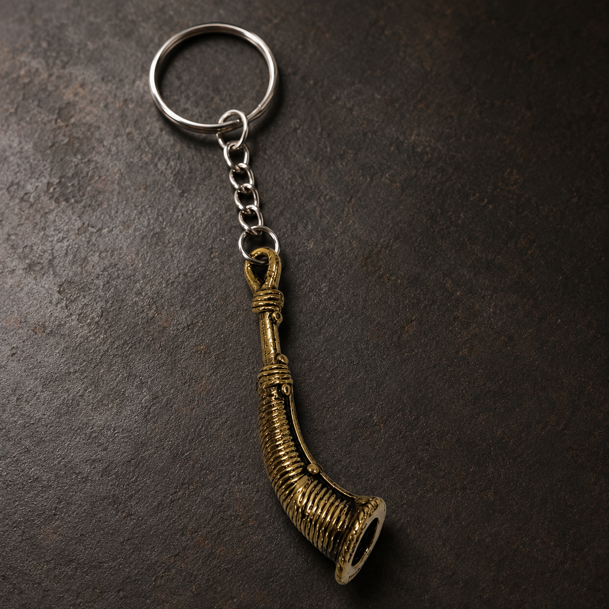 Detailed Dhokra Todi keyring showing wrapped bands, ribbing, rivets and brass patina