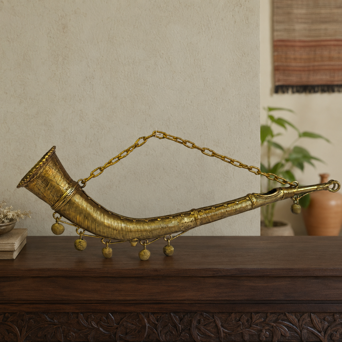 Dhokra Todi brass horn displayed on a walnut console in a calm Indian interior