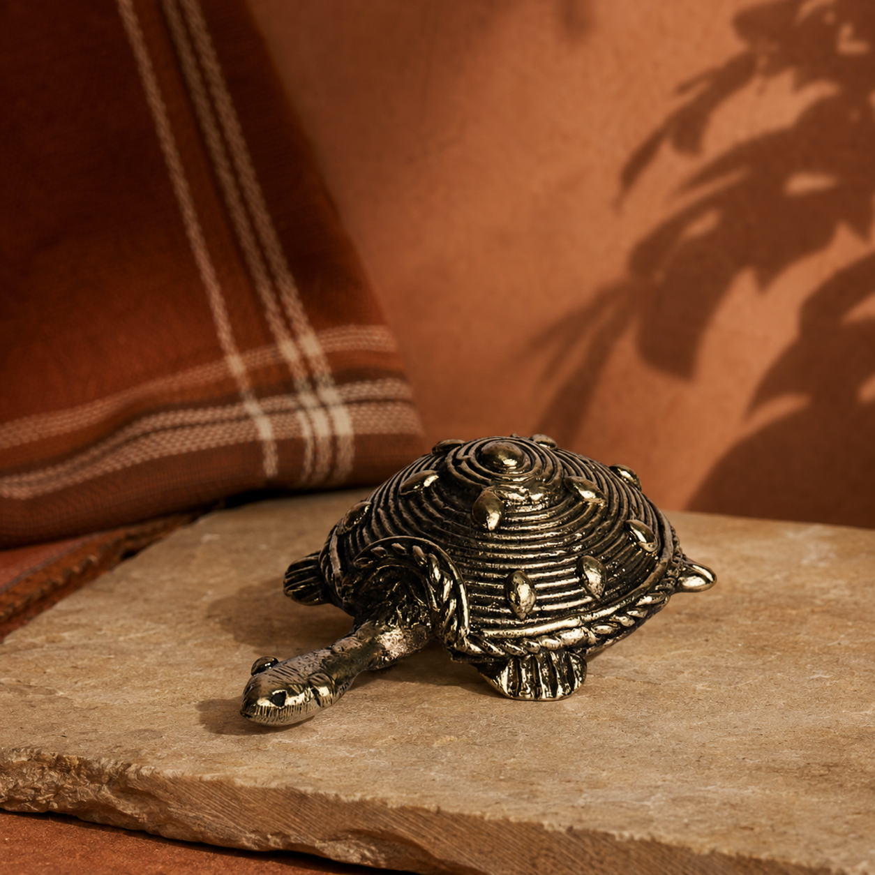 Bastar Dhokra tortoise displayed with earthy textile and stone styling