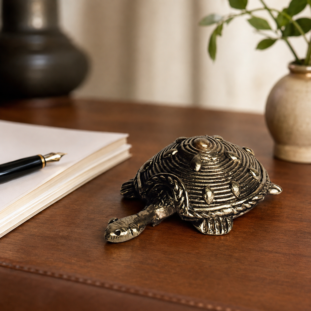 Dhokra tortoise used as a paperweight on a walnut writing desk