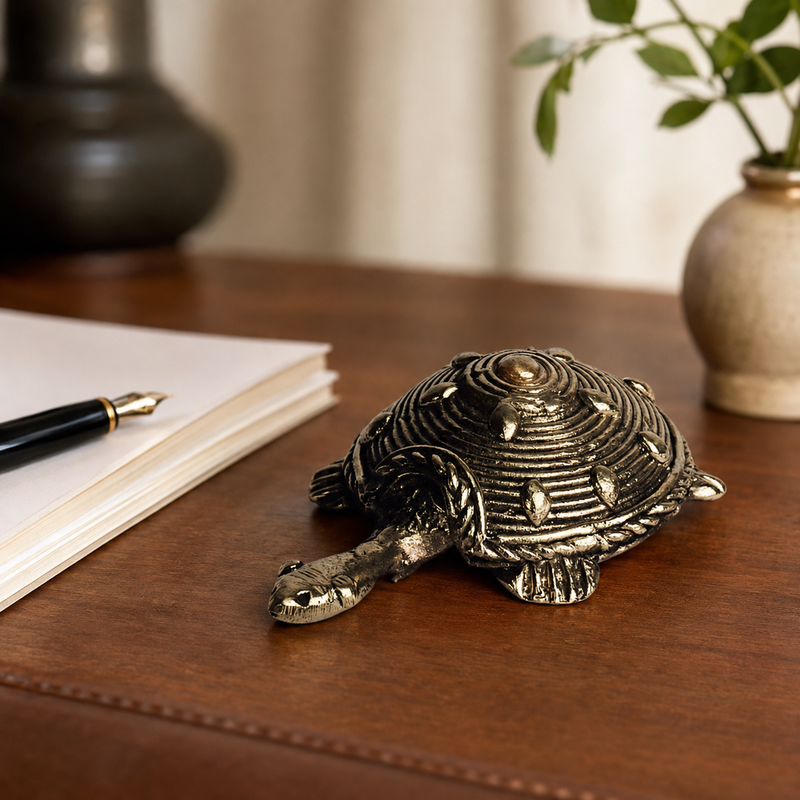Dhokra tortoise used as a paperweight on a walnut writing desk