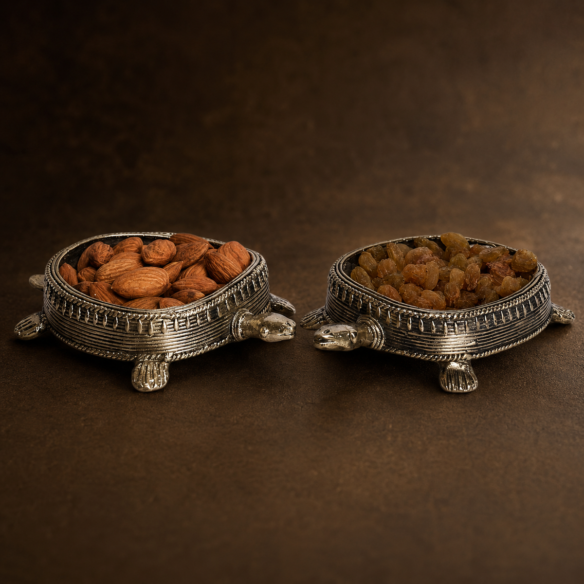Detailed view of two Dhokra tortoise dry fruit holders showing heads, feet, braided rims and coiled brass work