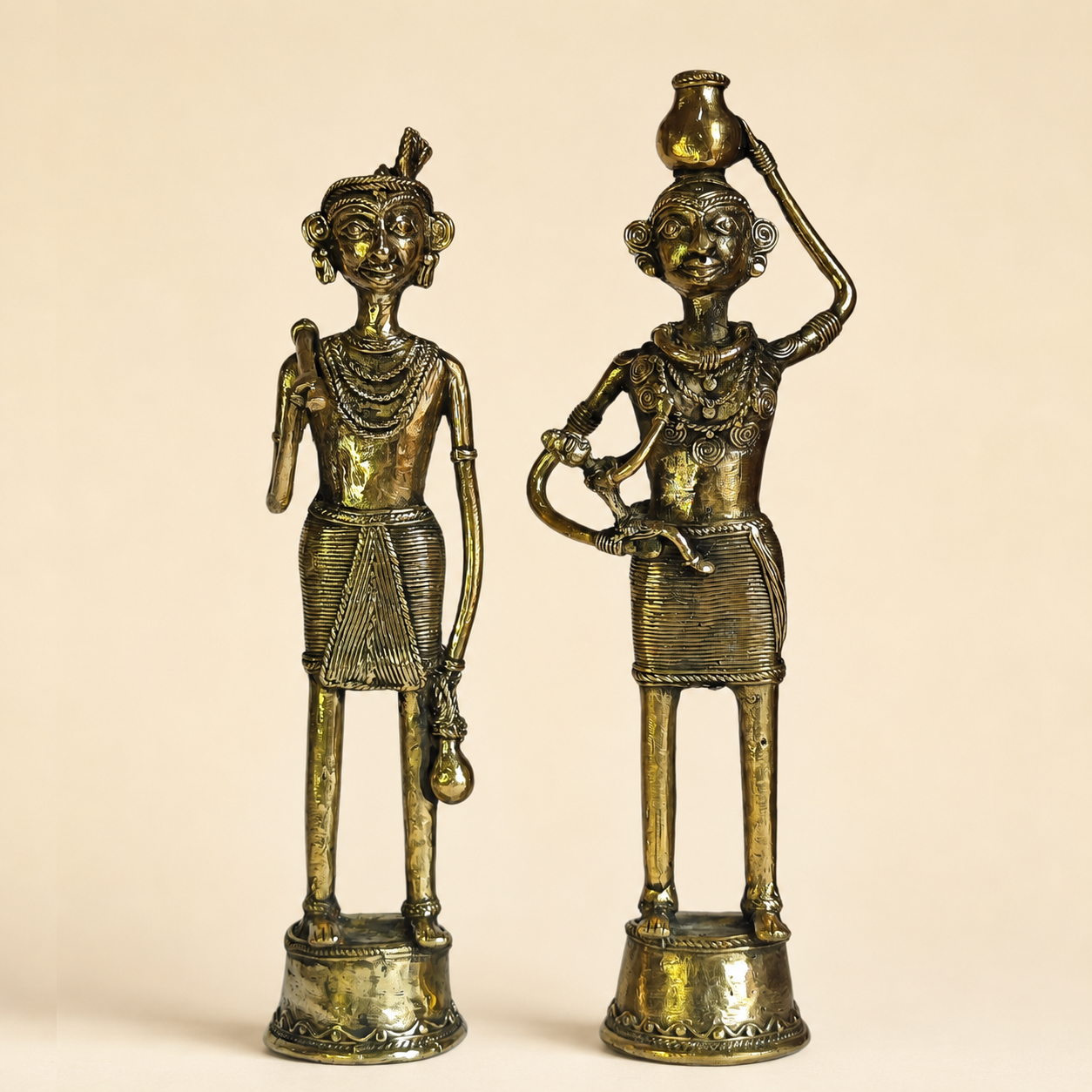 Dhokra Tribal Couple brass figurines on a warm ivory studio background
