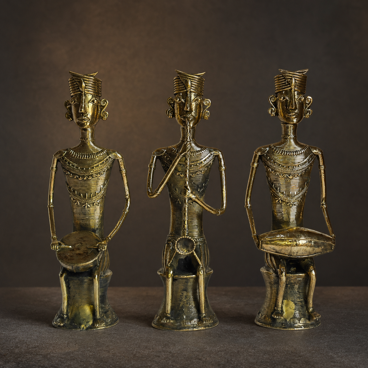 Detailed view of three Dhokra musicians showing headdresses, ornaments, instruments and brass casting texture