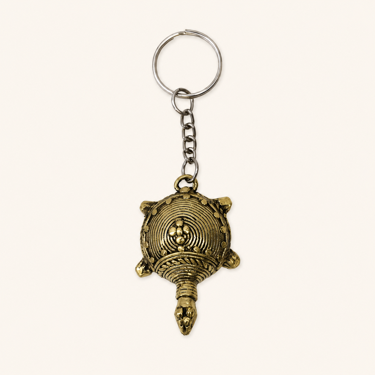 Dhokra turtle keyring on a warm ivory studio background