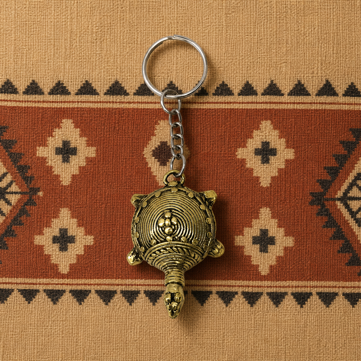 Dhokra turtle keyring on an earthy Bastar-inspired woven textile
