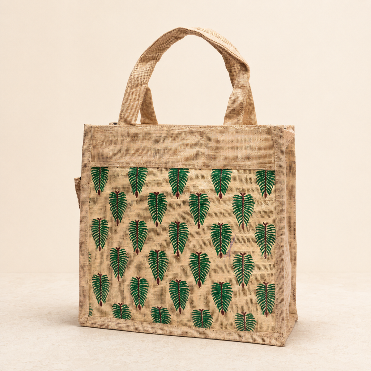 Catalogue view of a natural jute tote with repeated green leaf motifs