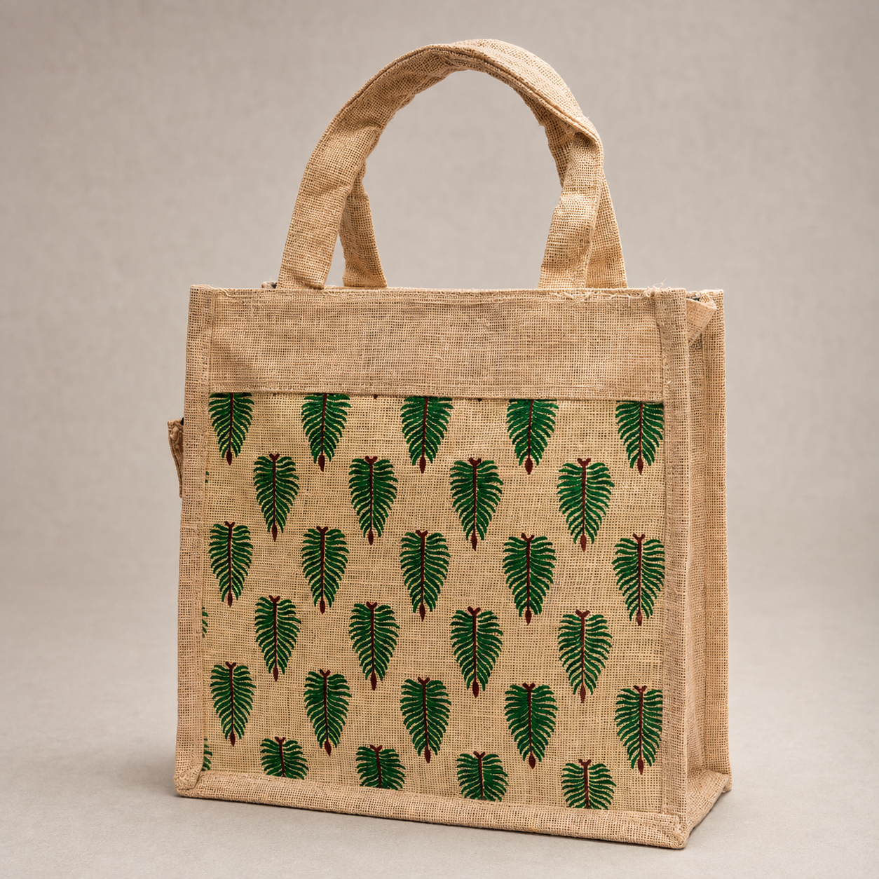 Detailed view of the natural jute weave, stitched edges and green leaf print