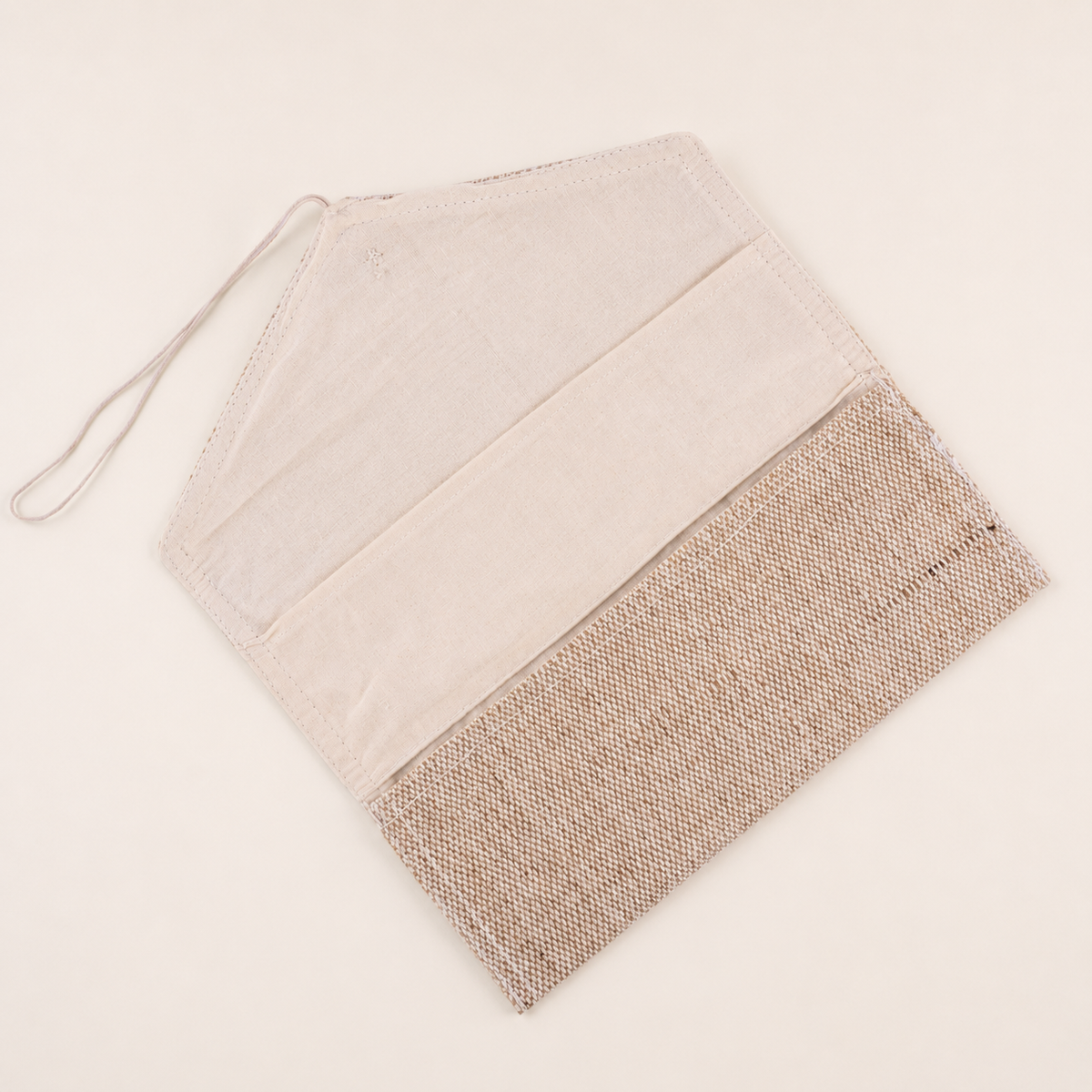 Open handcrafted jute fabric pouch on a clean ivory background