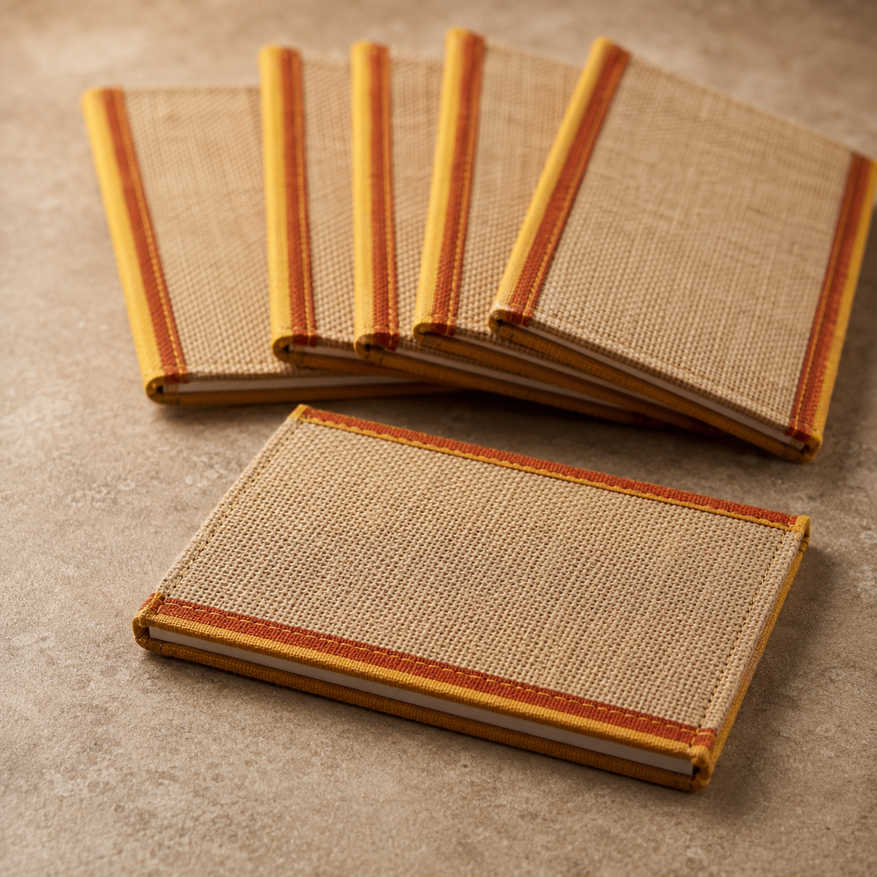 Close craftsmanship view of six jute notepads showing woven covers and bound edges