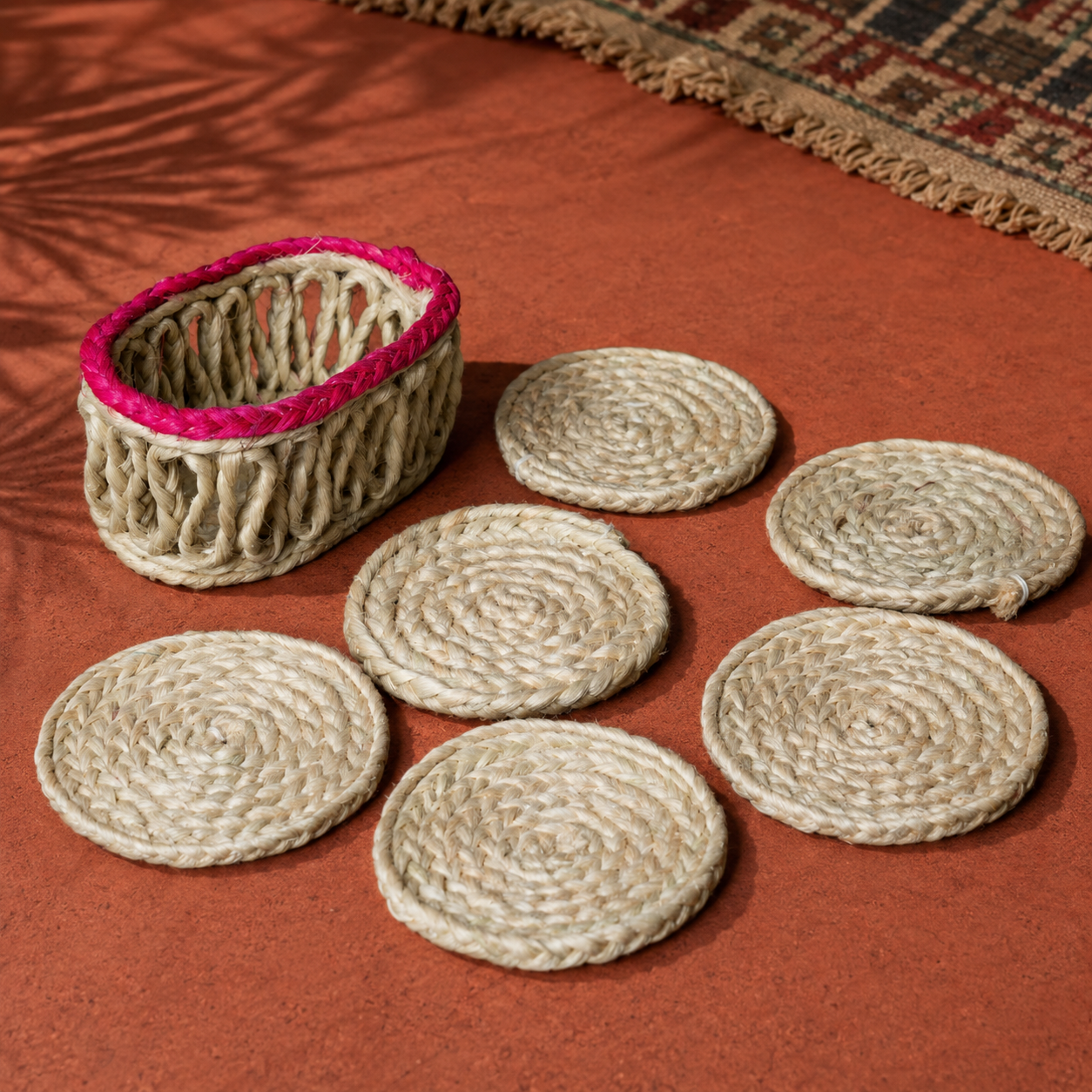 Six natural sisal coasters and woven holder arranged on an ochre craft-inspired surface