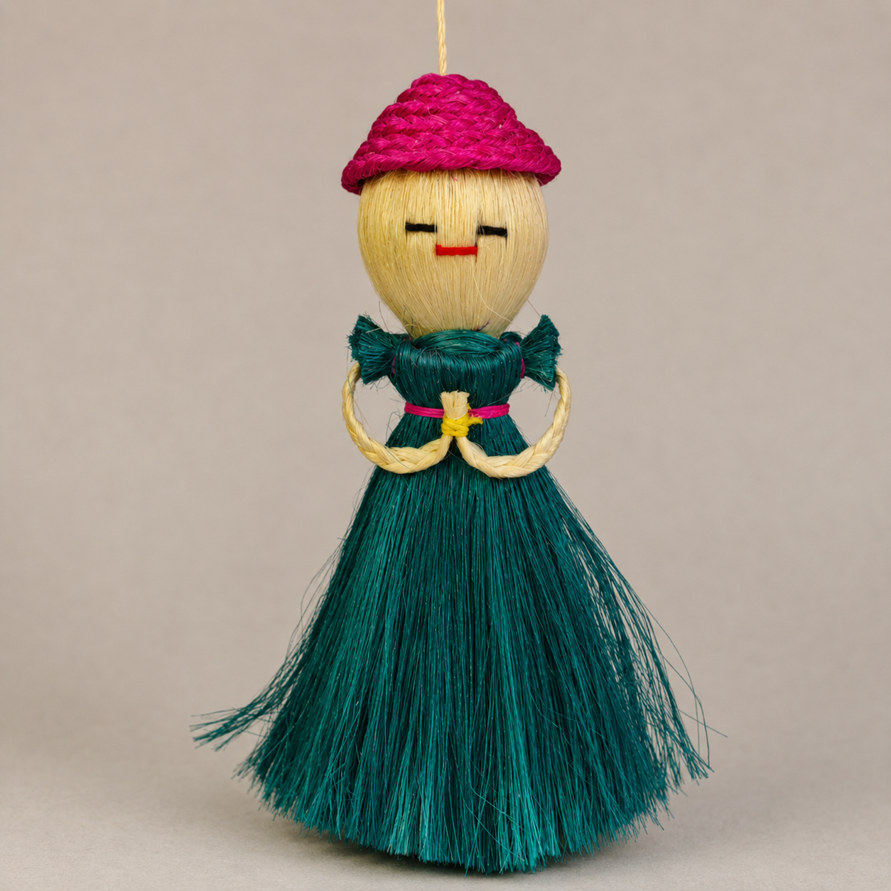 Close craftsmanship view of the braided cap, bound arms and natural fibres of a Bastar sisal doll