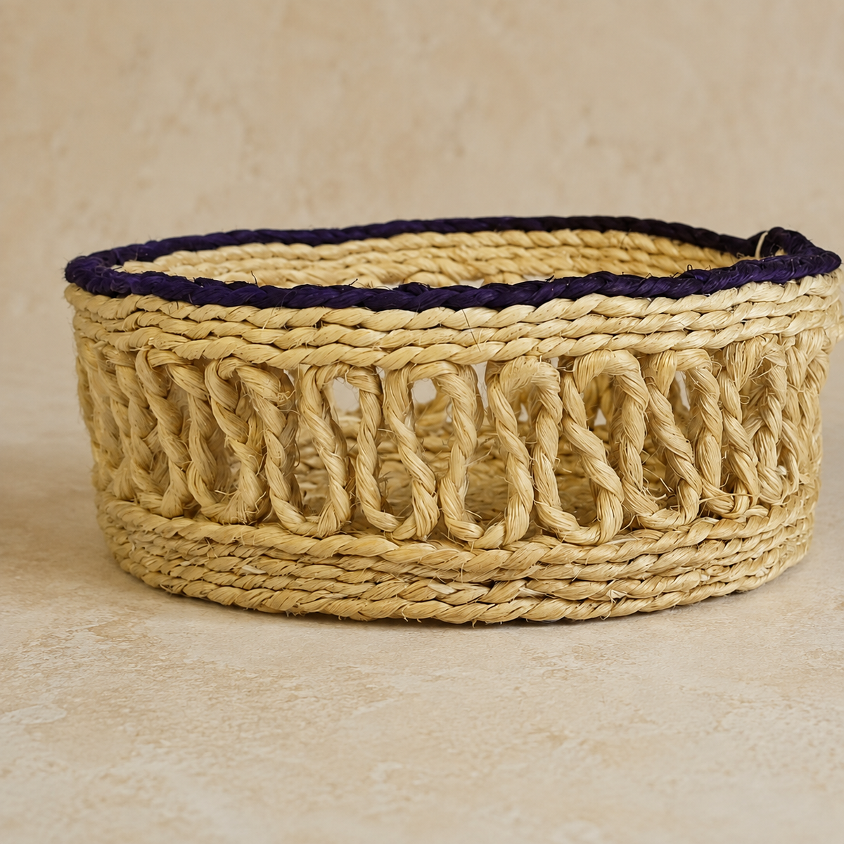 Close view of the braided rim and open-loop fibre weave on a handcrafted sisal container