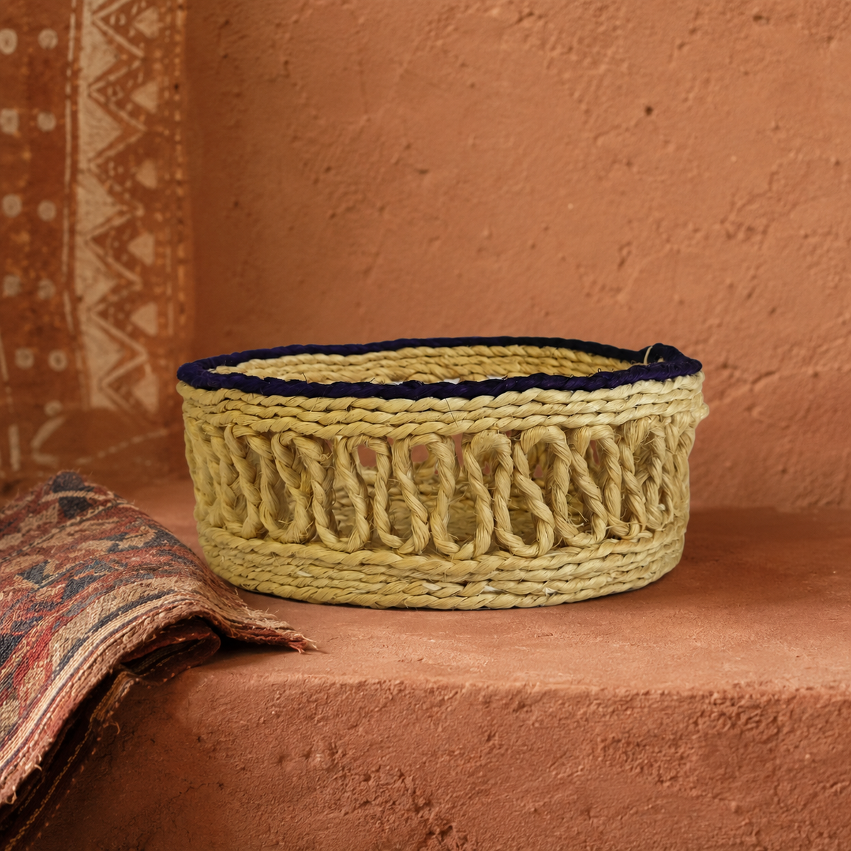 Bastar sisal table container styled with handwoven textile against a terracotta backdrop