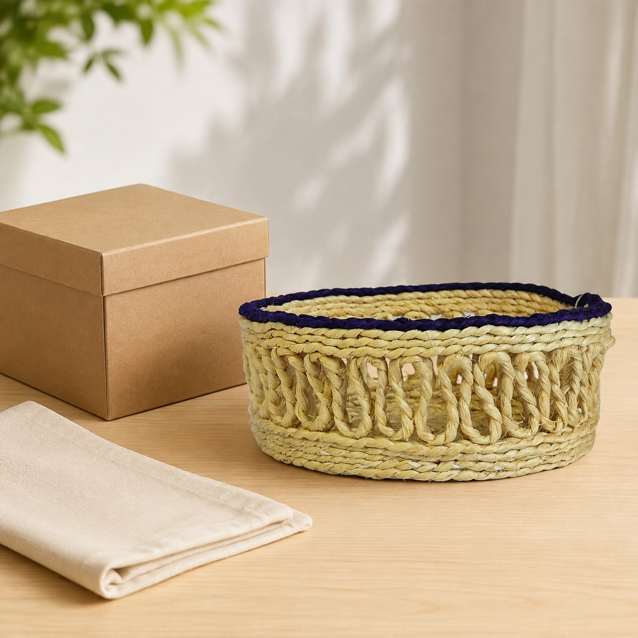 Handcrafted sisal table container presented beside a kraft gift box and folded cotton cloth