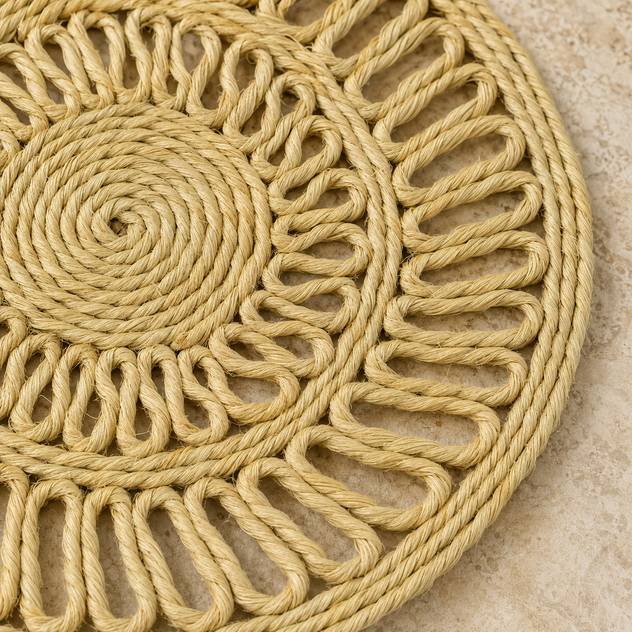 Close detail of the spiral, braided borders and open-loop weave of a natural sisal table mat