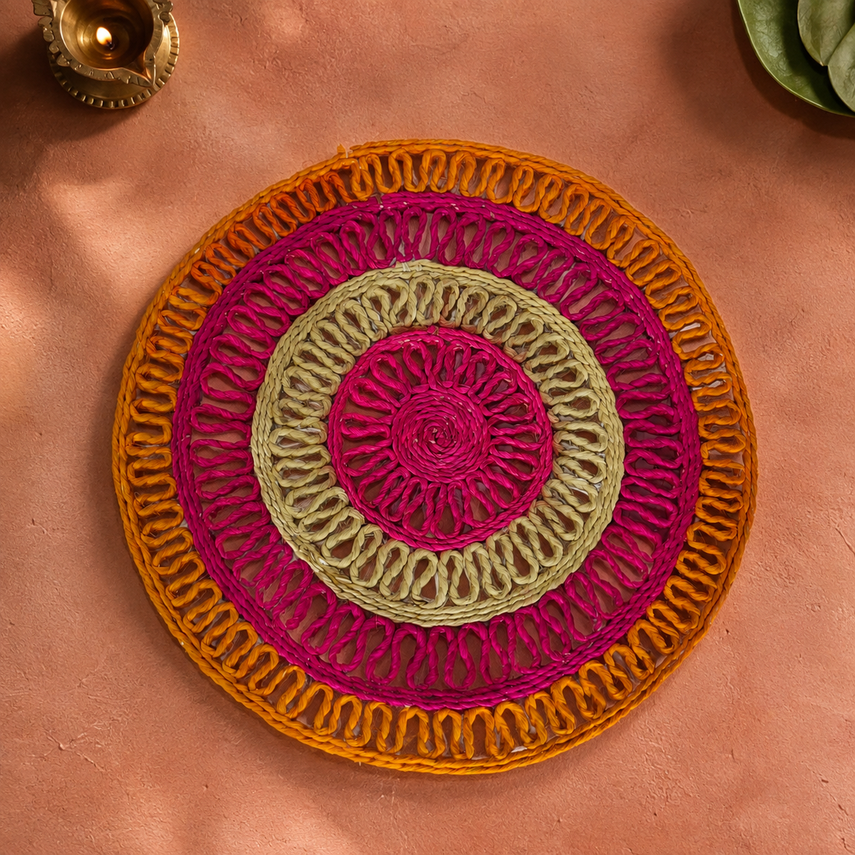 Bastar handcrafted sisal table mat displayed on a terracotta surface with a brass diya