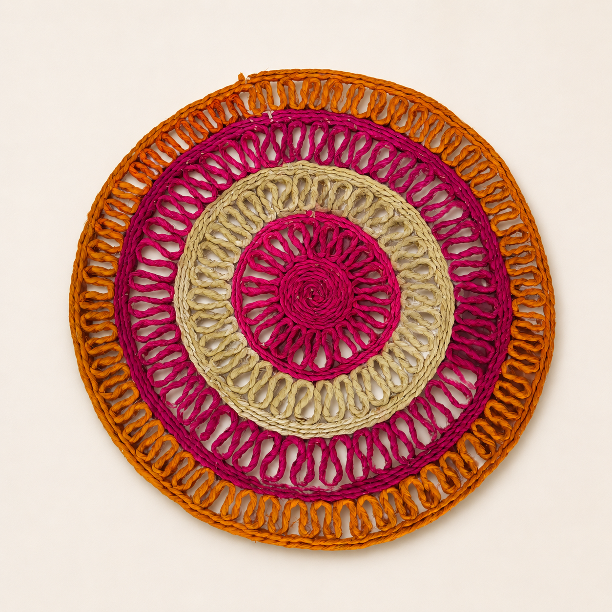 Multicolour handcrafted sisal table mat photographed overhead on a clean ivory background