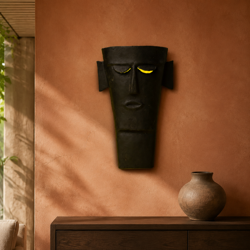 Bastar wrought iron tribal face mask displayed on a terracotta living room wall