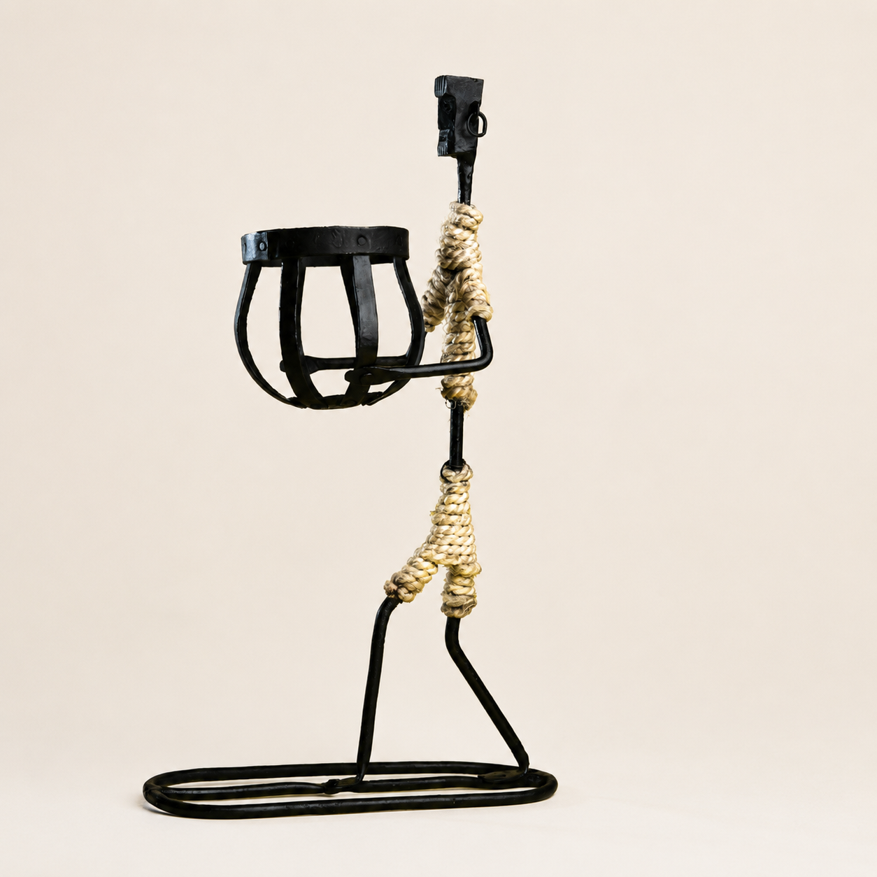 Bastar wrought iron tribal figure candle holder on a clean warm studio background